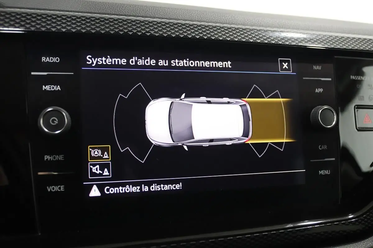 Écran du système d'aide au stationnement de la Volkswagen Polo 1.0 TSI noire, affichant la détection arrière en jaune.
