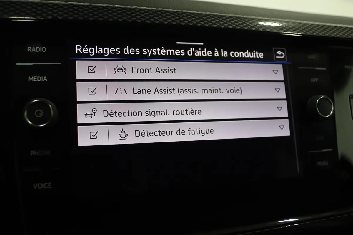 Écran tactile intérieur affichant les réglages des aides à la conduite sur Volkswagen Polo noire 2022.