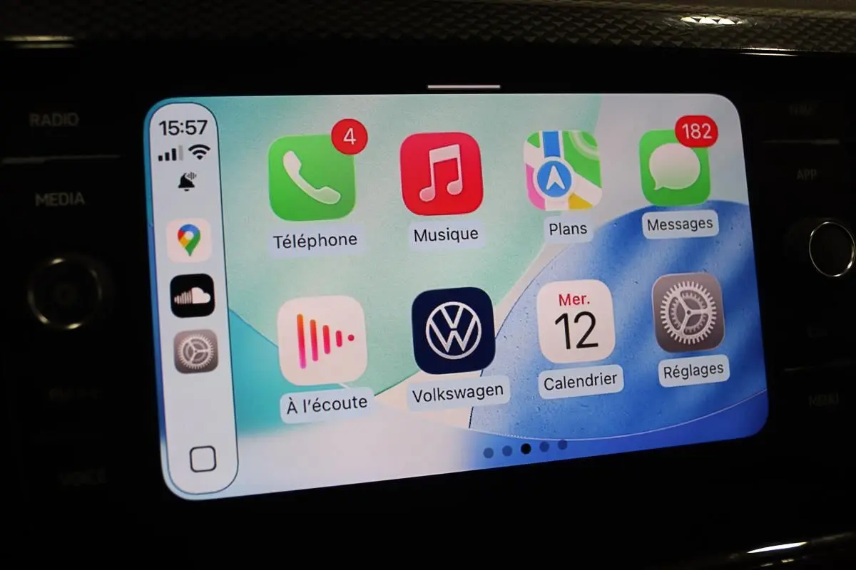Écran tactile du système Apple CarPlay dans une Volkswagen Polo noire, affichant les applications de navigation et communication.