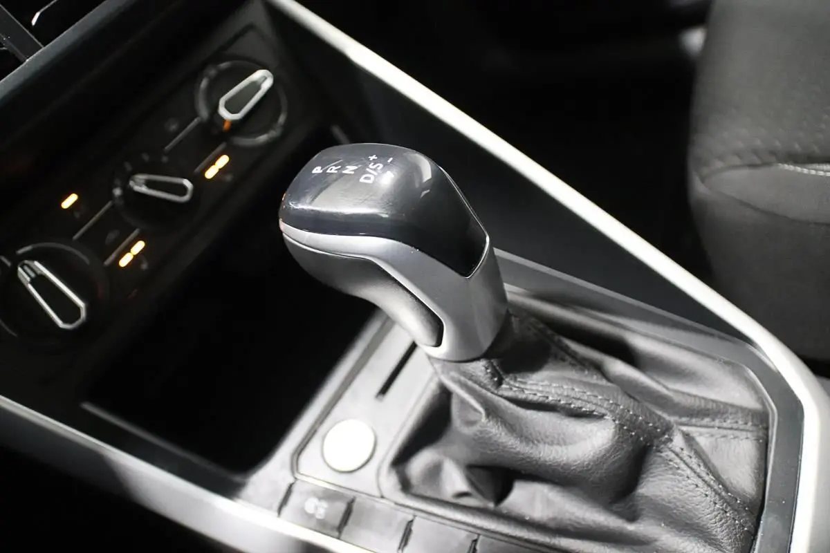 Le levier de vitesse automatique noir et argenté de la Volkswagen Polo 1.0 TSI 95 DSG, avec commandes de climatisation en arrière-plan.