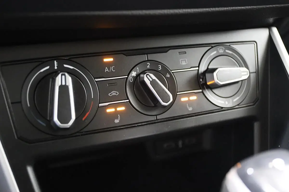 Gros plan sur les commandes de climatisation et sièges chauffants du Volkswagen Polo 2022 noir avec boîte automatique.