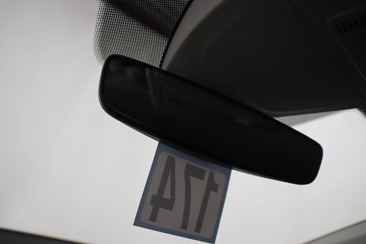 Rétroviseur intérieur noir d'une Volkswagen Polo 1.0 TSI 95 DSG vue depuis l'habitacle avec étiquette suspendue.