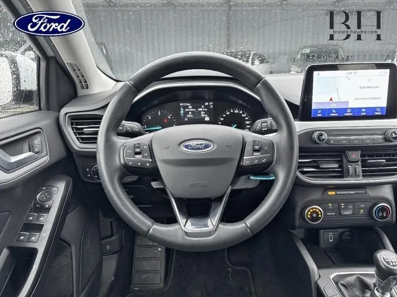 Vue intérieure centrée sur le volant cuir multifonction et tableau de bord numérique de la Ford Focus SW 2020.