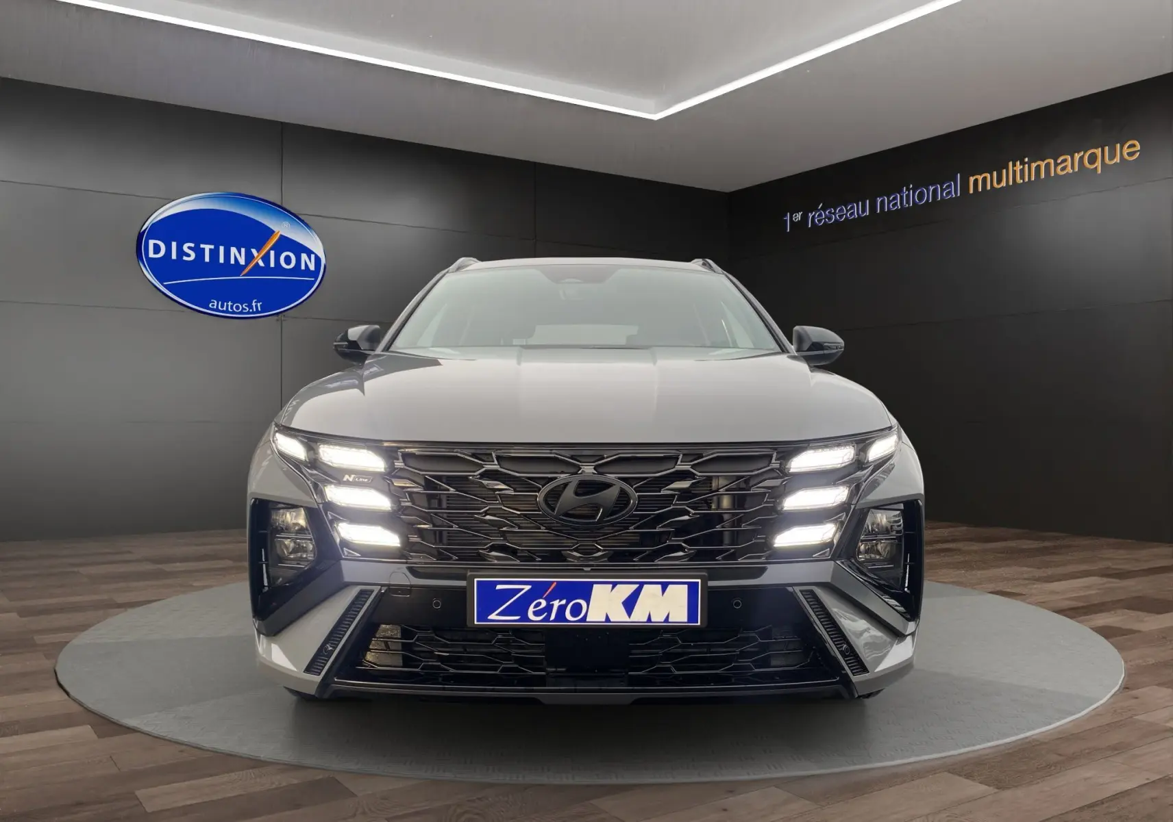 Vue de face du Hyundai Tucson 2026 gris Shadow avec calandre noire et feux LED distinctifs allumés.