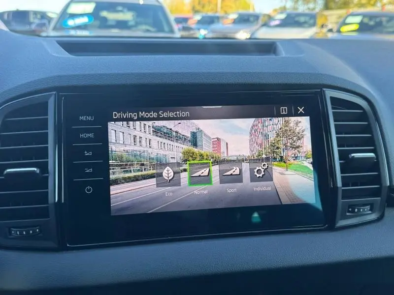 Écran tactile central du Skoda Karoq gris montrant la sélection du mode de conduite en intérieur.