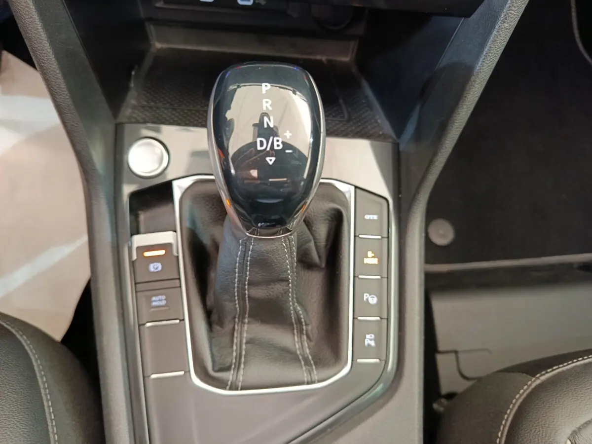 Vue rapprochée du levier de vitesse automatique noir avec coutures blanches du Volkswagen Tiguan hybride rechargeable.