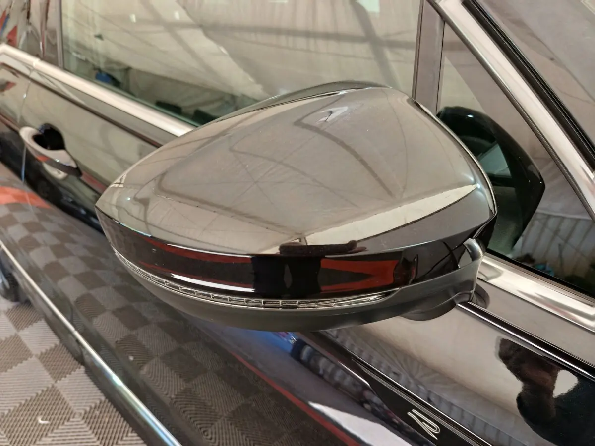 Rétroviseur droit noir brillant avec clignotant intégré sur Volkswagen Tiguan 1.4 EHYBRID 2023, vue rapprochée.