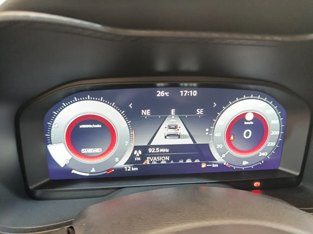 Affichage numérique du combiné d'instruments du Nissan Juke bleu, vue frontale du tableau de bord avec navigation et compte-tours.
