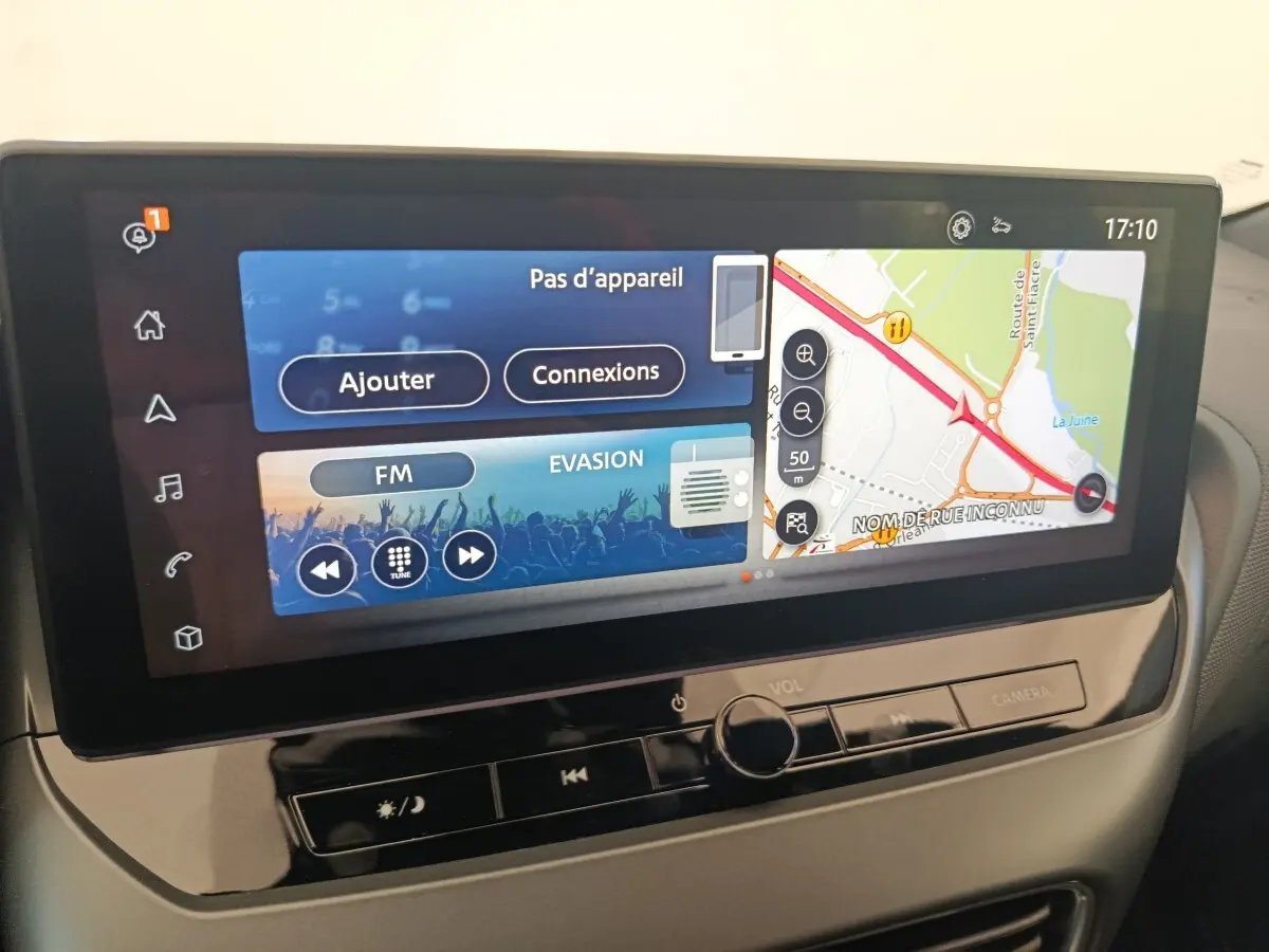 Écran tactile central 12,3 pouces du Nissan Juke bleu 2025 affichant navigation et radio FM en intérieur.