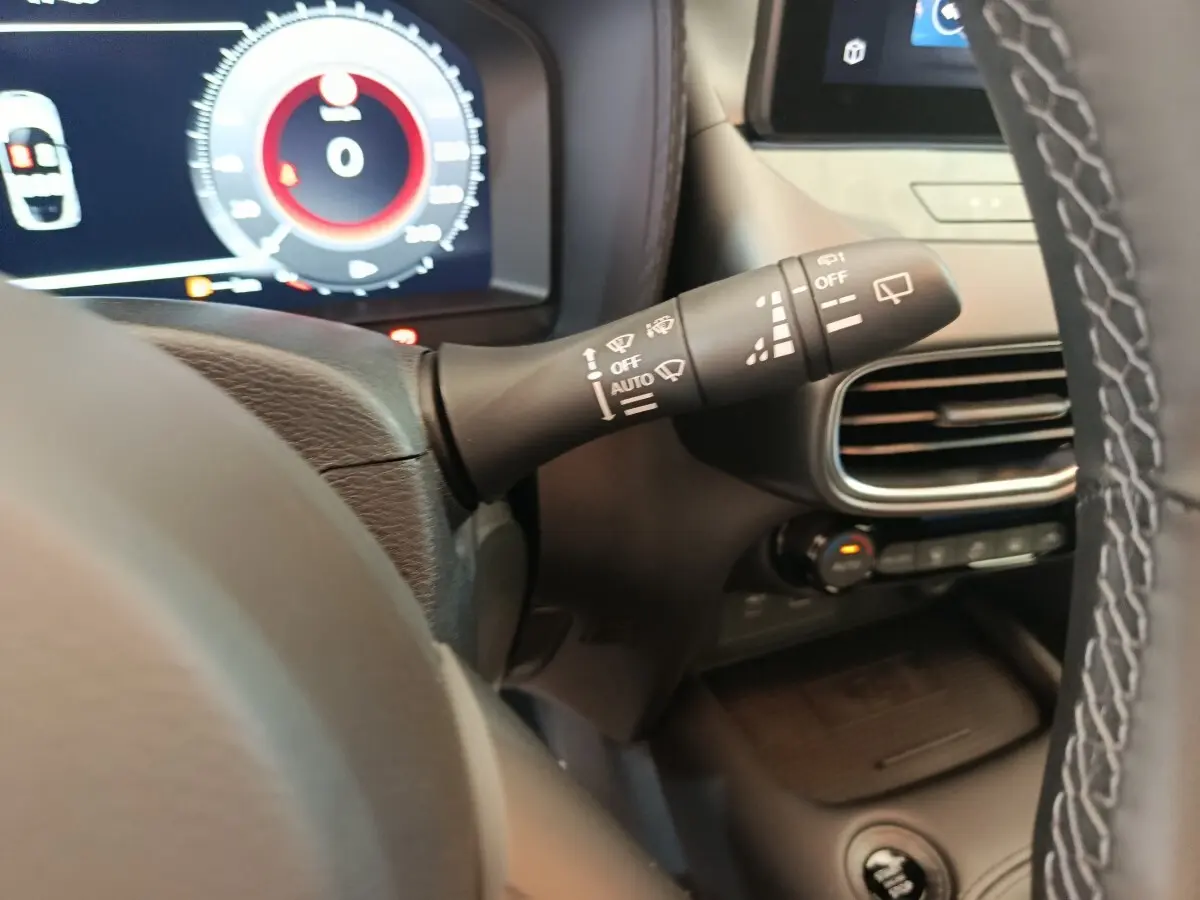 Détail du commodo d’essuie-glace à gauche du volant dans l’habitacle du Nissan Juke bleu 2025.