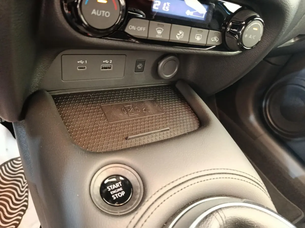 Gros plan sur la console centrale noire du Nissan Juke bleu, avec bouton Start/Stop et ports USB visibles.