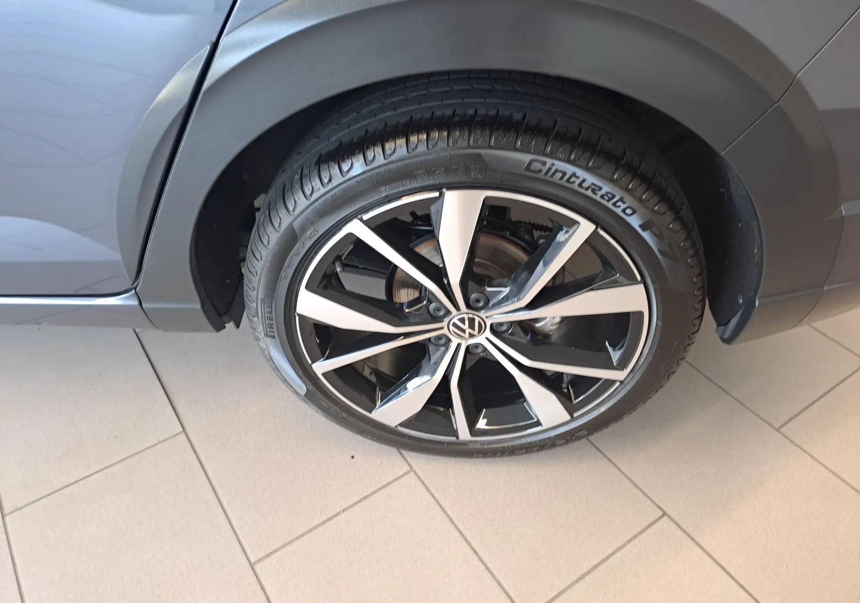 Gros plan sur la jante alliage 18'' Misano noire et argent du côté arrière droit du Volkswagen Taigo gris cendre 2025.