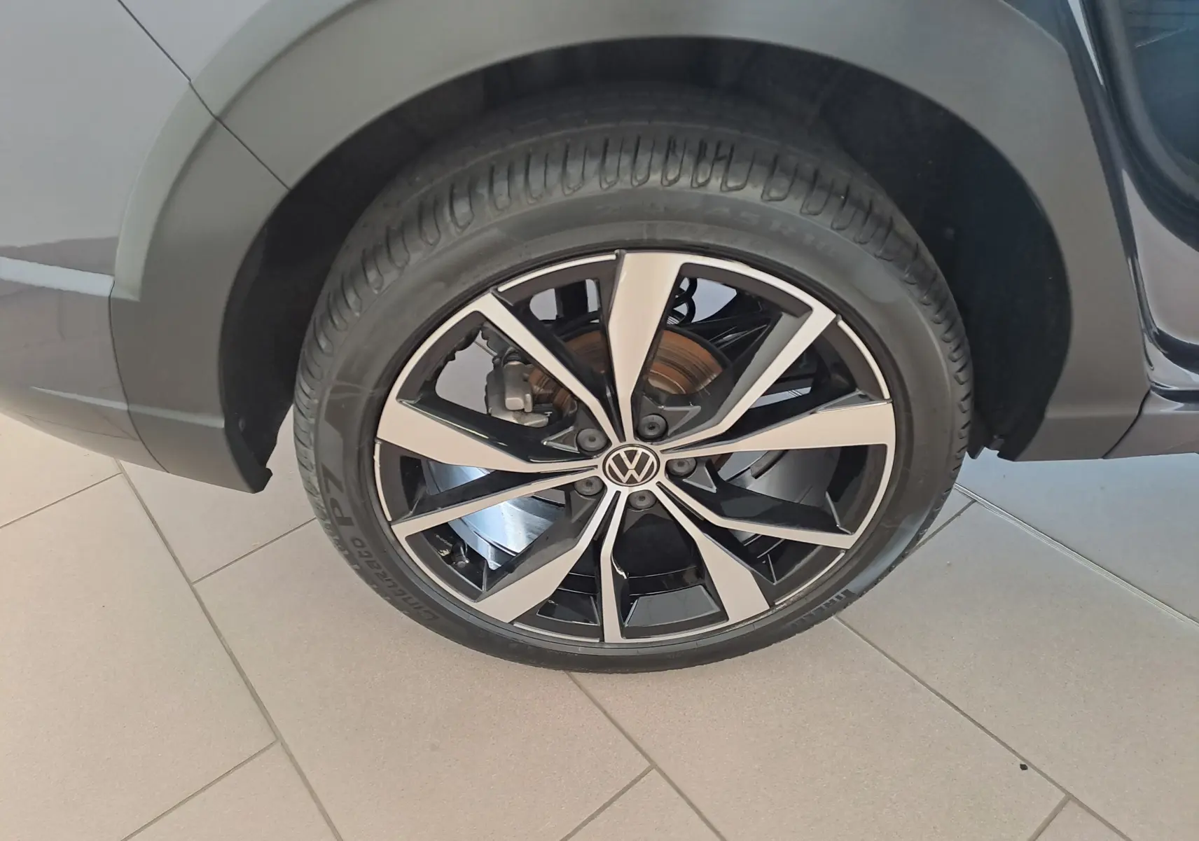 Gros plan sur la jante alliage 18'' Misano bicolore noir et argent du Volkswagen Taigo gris cendre côté arrière droit.