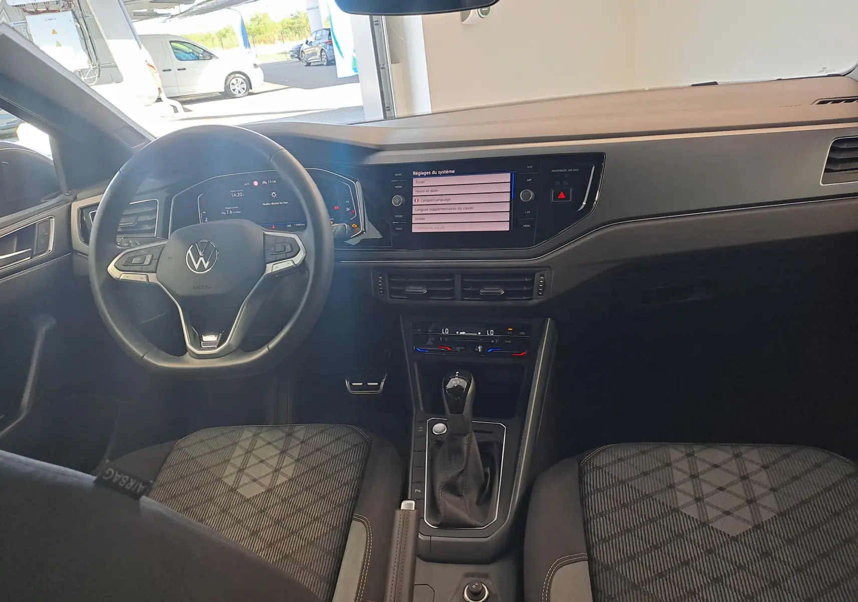 Vue intérieure avant du Volkswagen Taigo 2025, tableau de bord moderne avec écran tactile et volant multifonction noir.