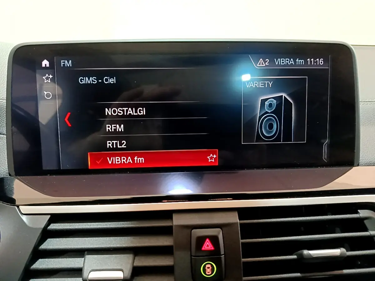 Écran tactile multimédia affichant les stations radio dans l'habitacle d'une BMW X3 noir, version Luxury 2019.