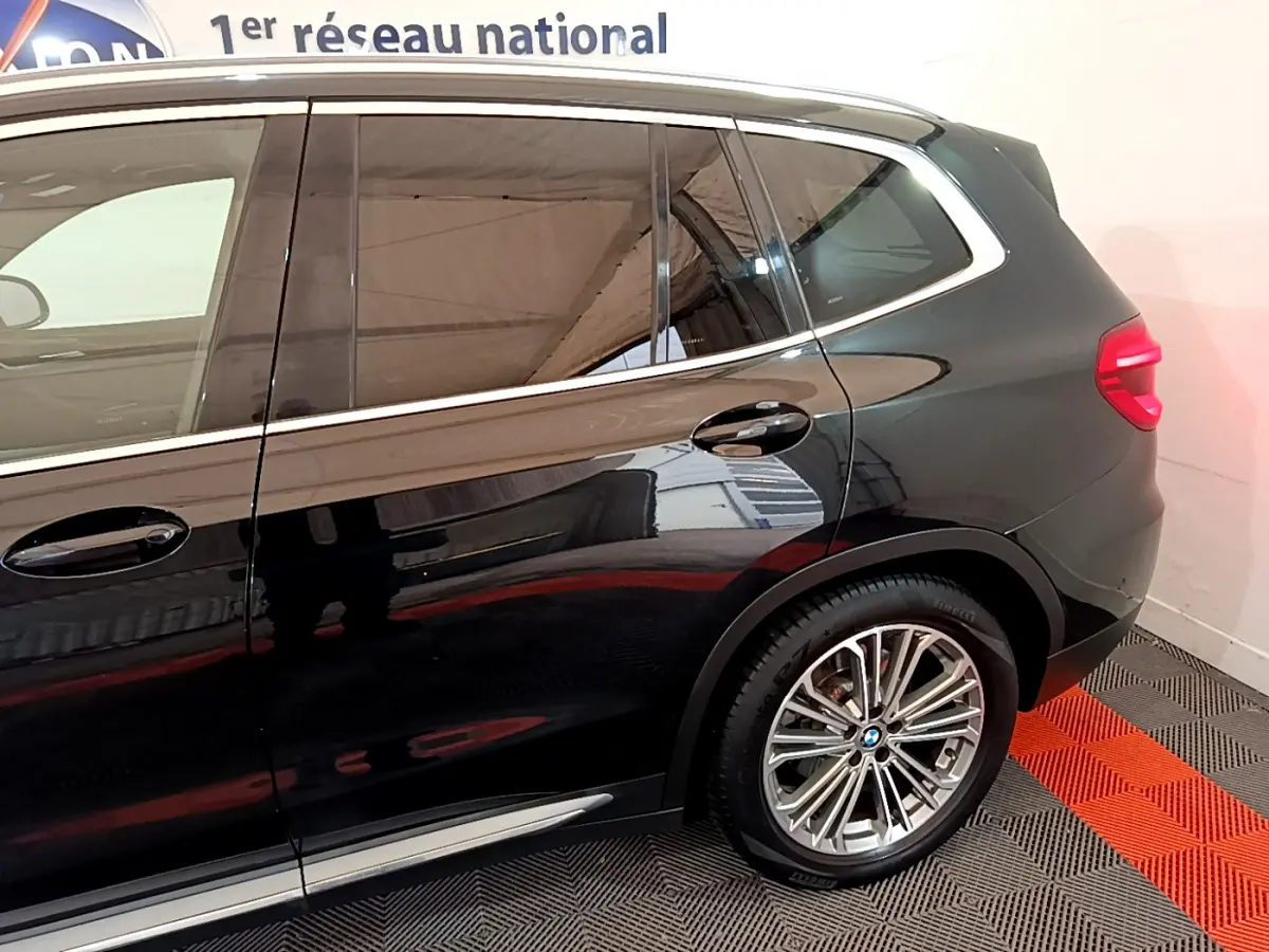 Vue latérale droite du BMW X3 noir 2019 mettant en valeur les jantes alliage et les contours chromés des vitres.