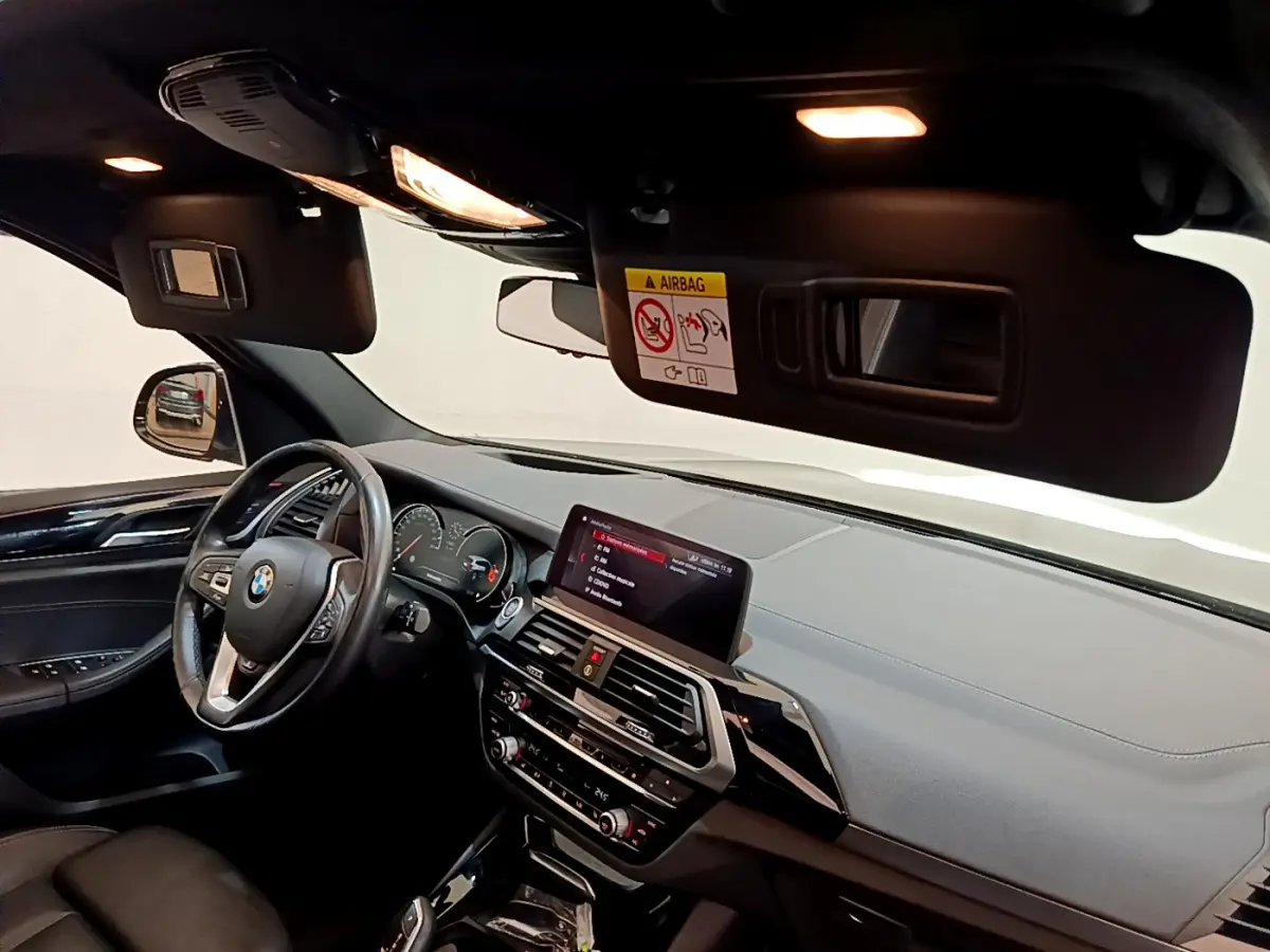 Intérieur noir de BMW X3 xDrive20d 2019, vue côté conducteur sur tableau de bord et écran tactile central.