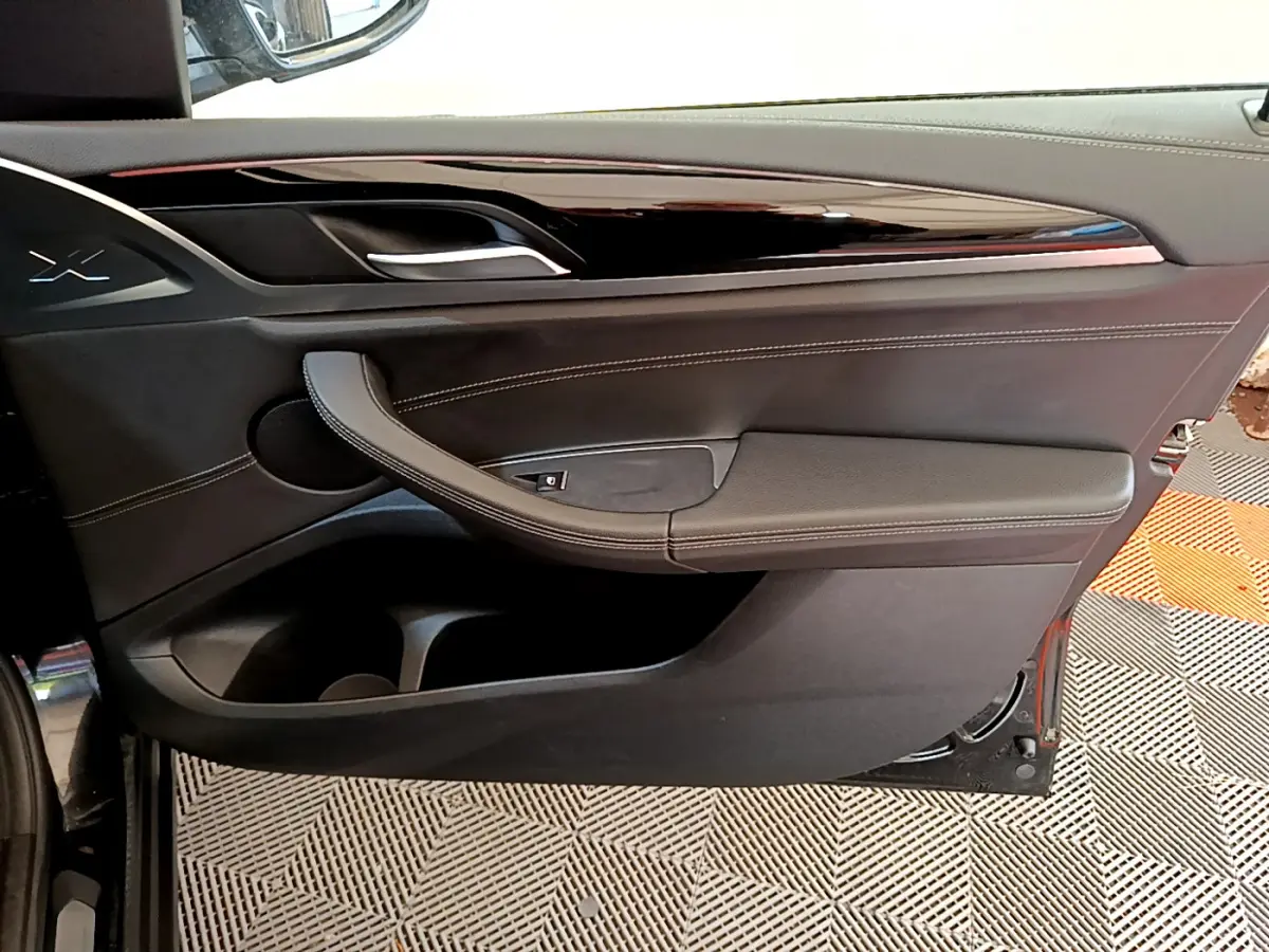 Panneau de porte intérieur côté gauche en cuir noir avec surpiqûres blanches sur BMW X3 xDrive20d 2019.