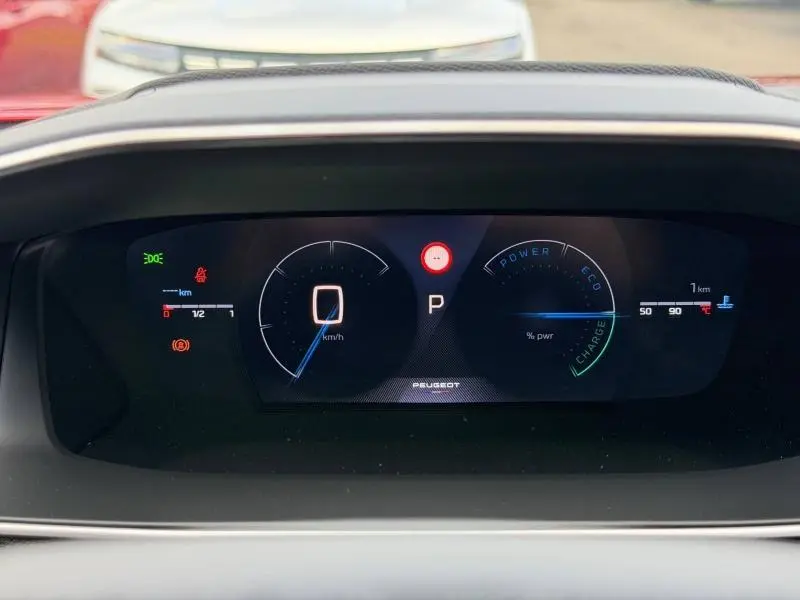 Vue rapprochée du tableau de bord numérique du Peugeot 2008 Hybrid, affichage des compteurs et voyants allumés.