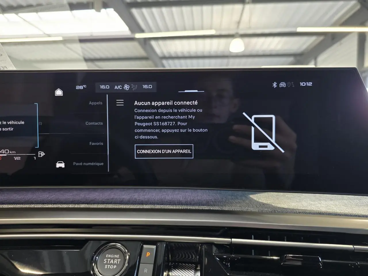 Vue rapprochée de l'écran tactile et console centrale du Peugeot 3008 hybride 2025 avec affichage connecté et bouton start/stop.