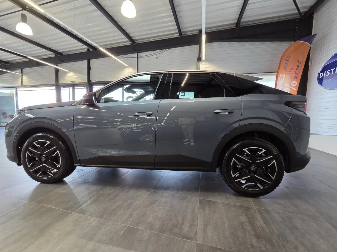 Vue de profil côté gauche du Peugeot 3008 2025 bleu clair avec jantes alliage noires et toit noir brillant.