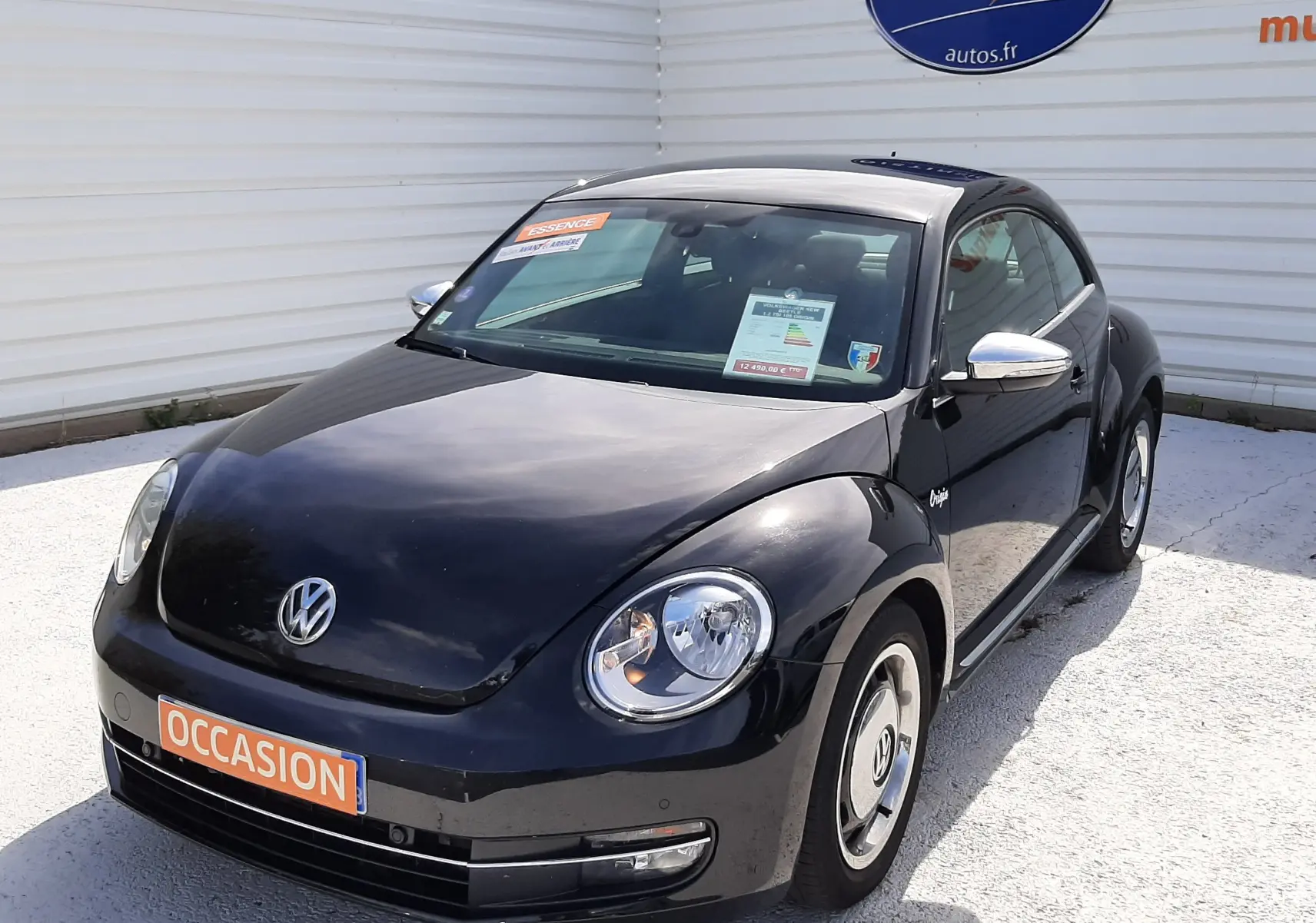 Volkswagen New Beetle noir en 3/4 avant droit, avec jantes spécifiques et rétroviseurs chromés visibles.