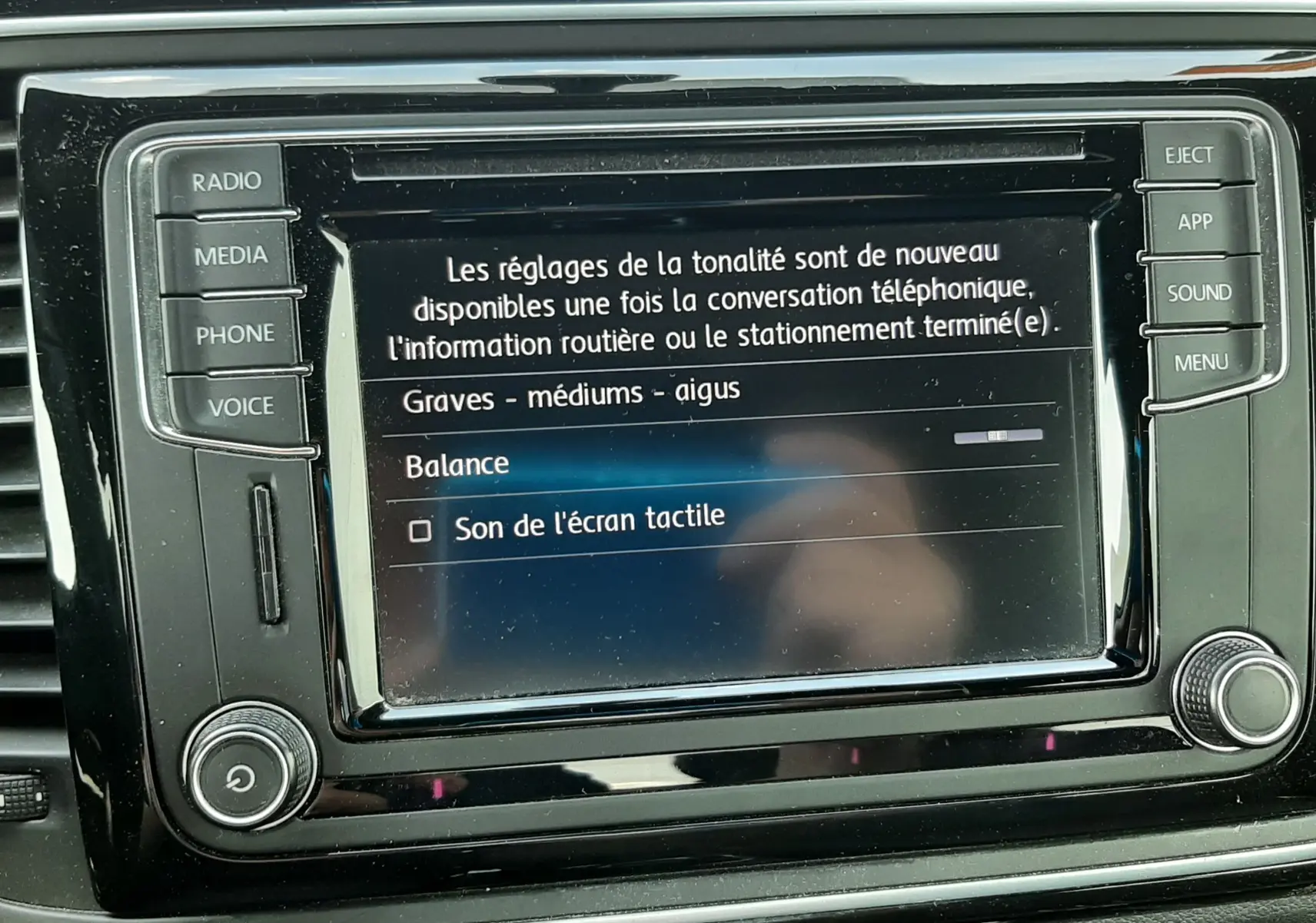 Écran tactile central de la Volkswagen New Beetle 1.2 TSI 2015, affichant les réglages audio, intérieur noir.
