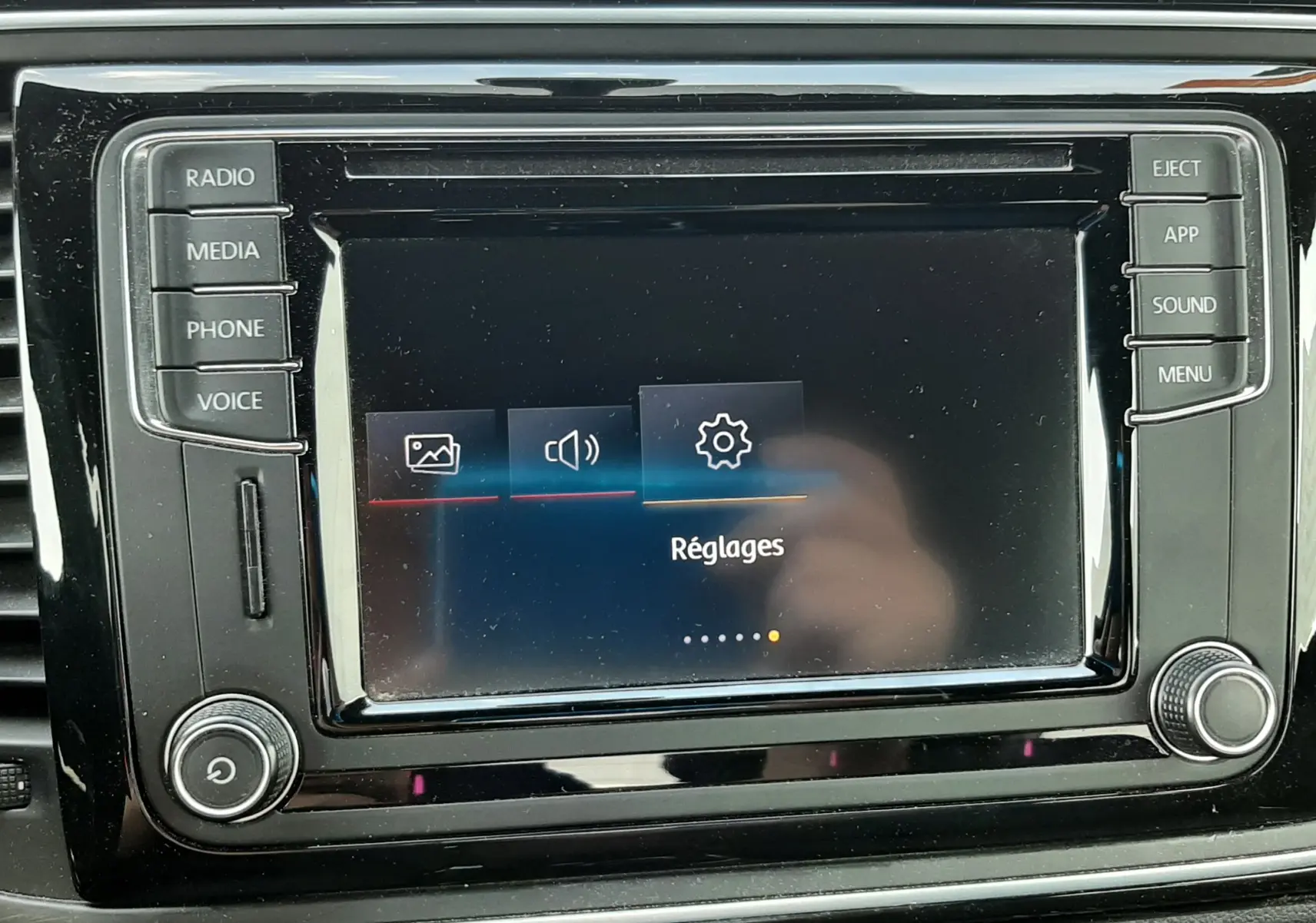 Gros plan sur l'écran tactile central noir du Volkswagen New Beetle 2015 affichant le menu Réglages.