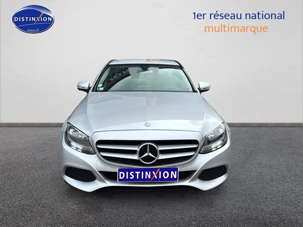 Vue frontale d'une Mercedes Classe C 180 d business gris alu avec calandre étoilée et phares LED visibles.