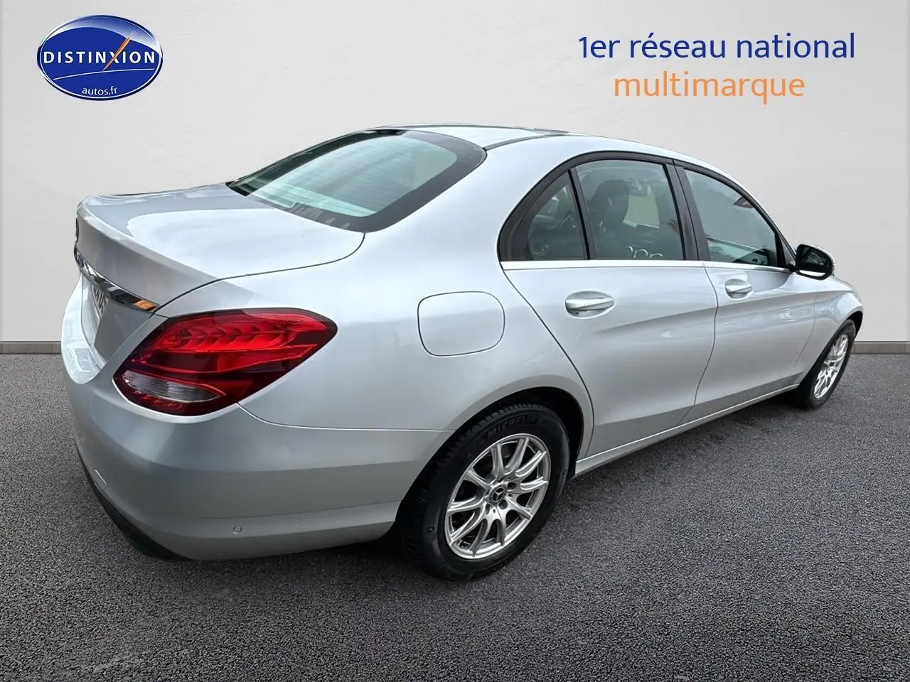 Mercedes Classe C 180 d business gris alu vue 3/4 arrière droit, jantes alliage et feux arrière rouges visibles.