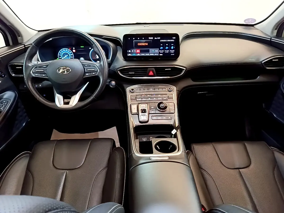 Intérieur noir du Hyundai Santa Fe 2022 vu de face, avec tableau de bord numérique et écran tactile central lumineux.