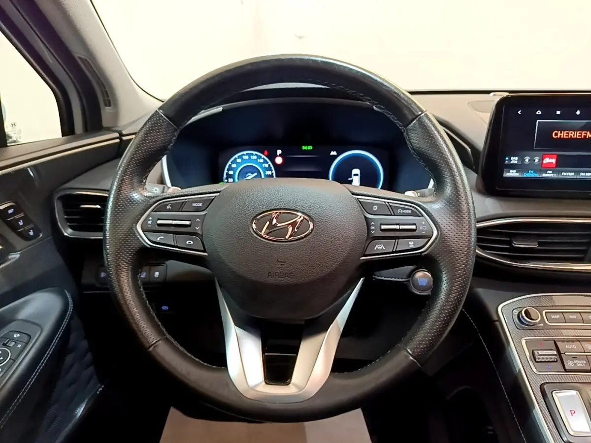 Vue centrée sur le volant cuir noir du Hyundai Santa Fe 2022 avec tableau de bord numérique et écran tactile.