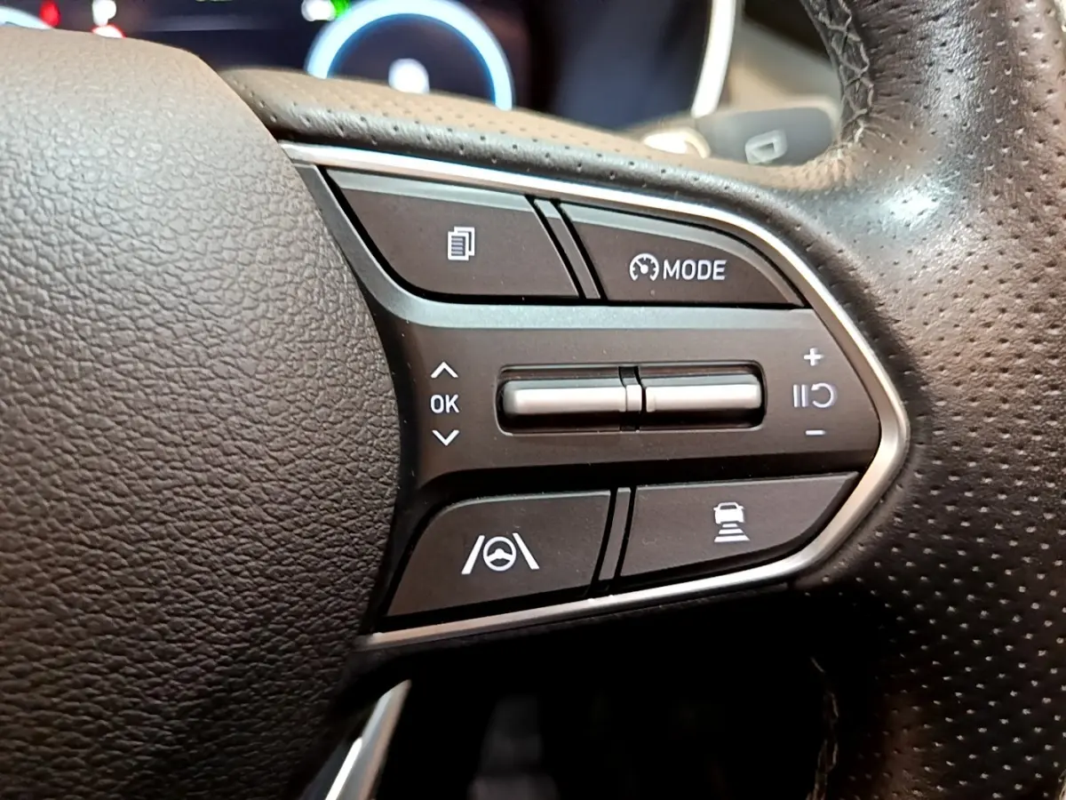 Gros plan sur les commandes noires du volant cuir du Hyundai Santa Fe hybride 2022, côté droit avec boutons multifonctions.