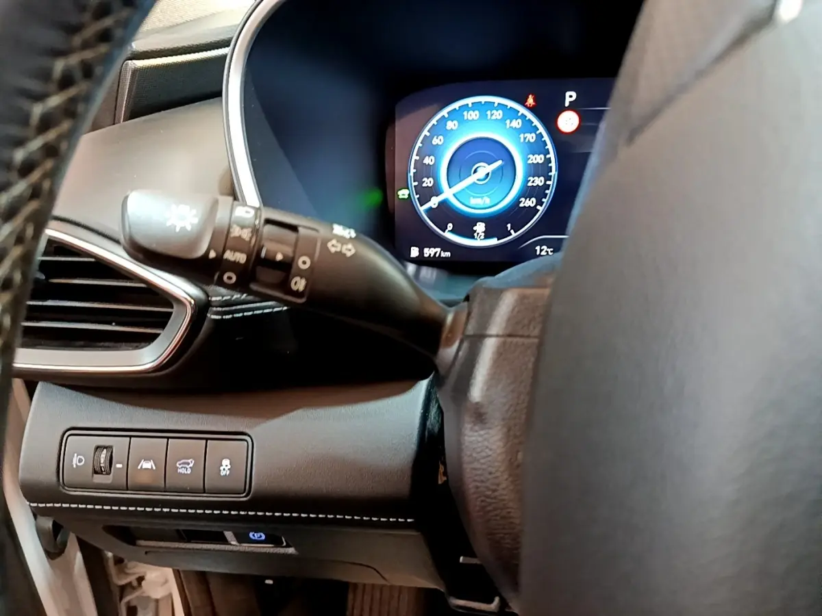 Détail du tableau de bord noir du Hyundai Santa Fe hybride 2022, avec affichage numérique bleu du compteur de vitesse.