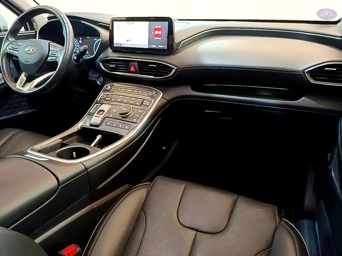 Vue intérieure du tableau de bord et console centrale du Hyundai Santa Fe 2022 avec écran tactile et finition cuir noire.
