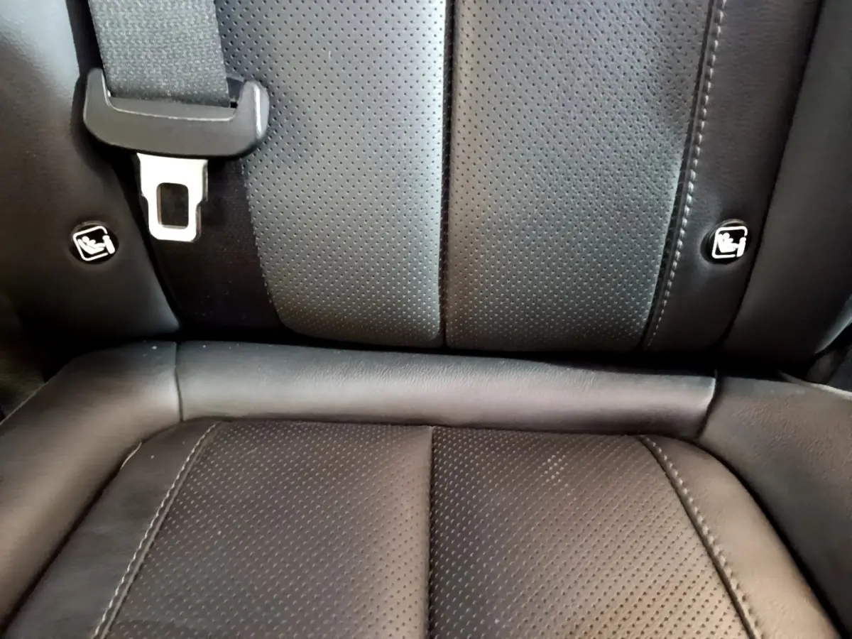 Gros plan sur la banquette arrière en cuir noir du Hyundai Santa Fe, montrant les fixations Isofix et la ceinture de sécurité.