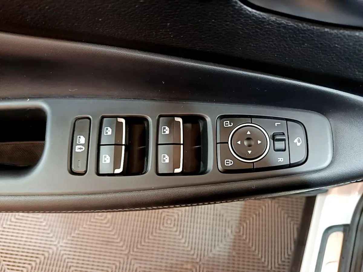 Panneau de commandes des vitres et rétroviseurs côté conducteur du Hyundai Santa Fe blanc, intérieur noir.
