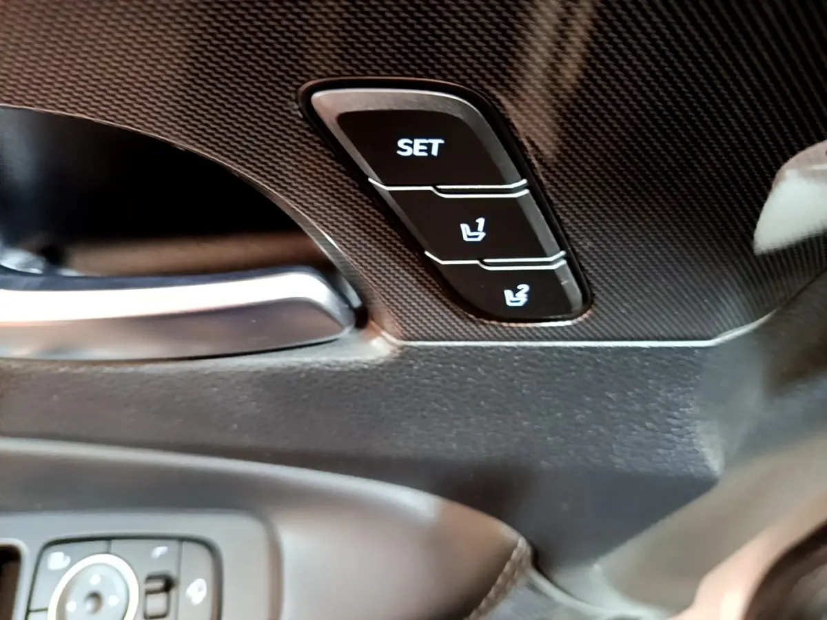 Gros plan sur les boutons de réglage mémoire des sièges noirs dans l'habitacle du Hyundai Santa Fe blanc 2022.