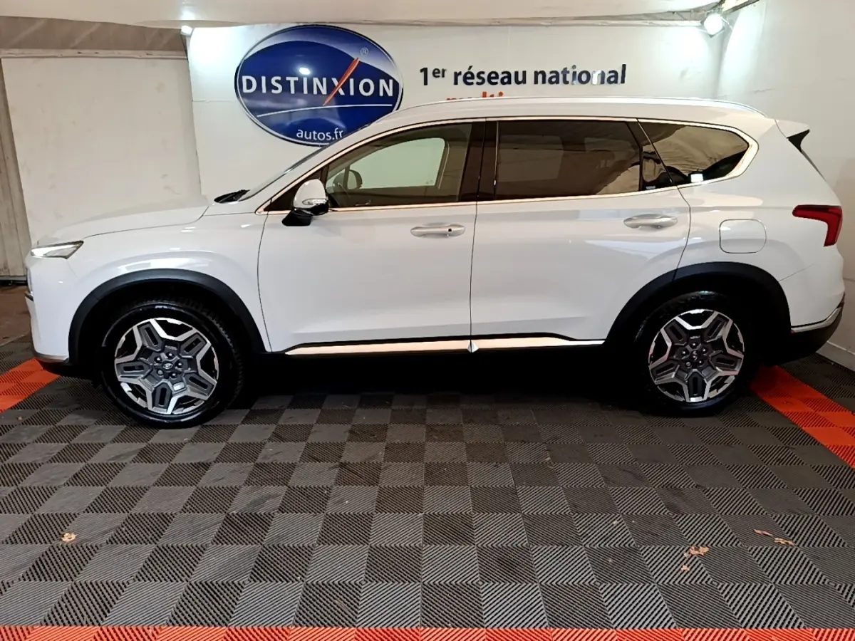 Vue latérale droite d'un Hyundai Santa Fe blanc 2022, SUV hybride avec jantes alliage et vitres teintées.