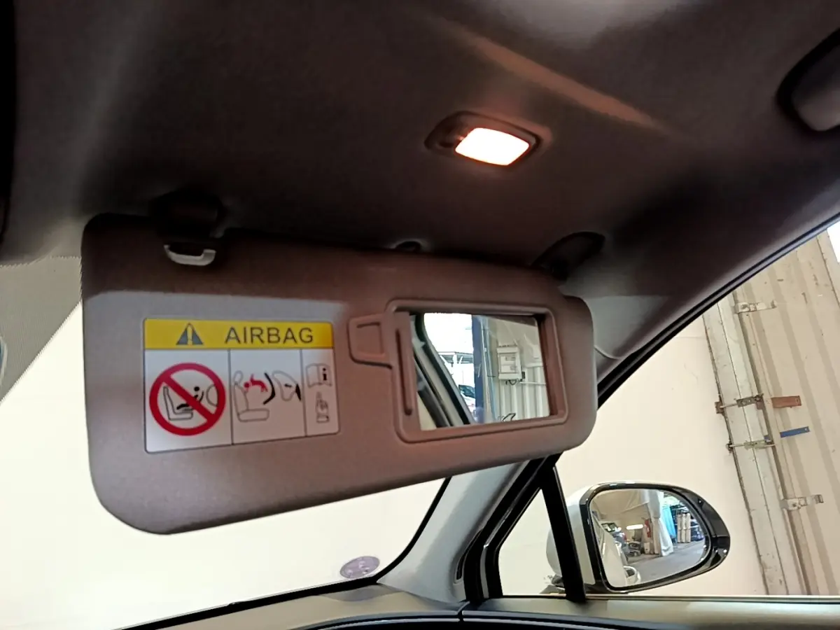 Détail du pare-soleil côté conducteur avec miroir et avertissement airbag dans un Hyundai Santa Fe blanc 2022.