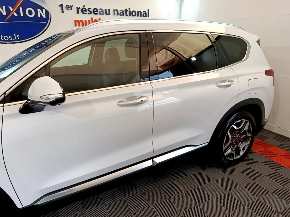 Profil côté gauche du Hyundai Santa Fe blanc 2022, avec jantes alliage et rétroviseur blanc brillant.