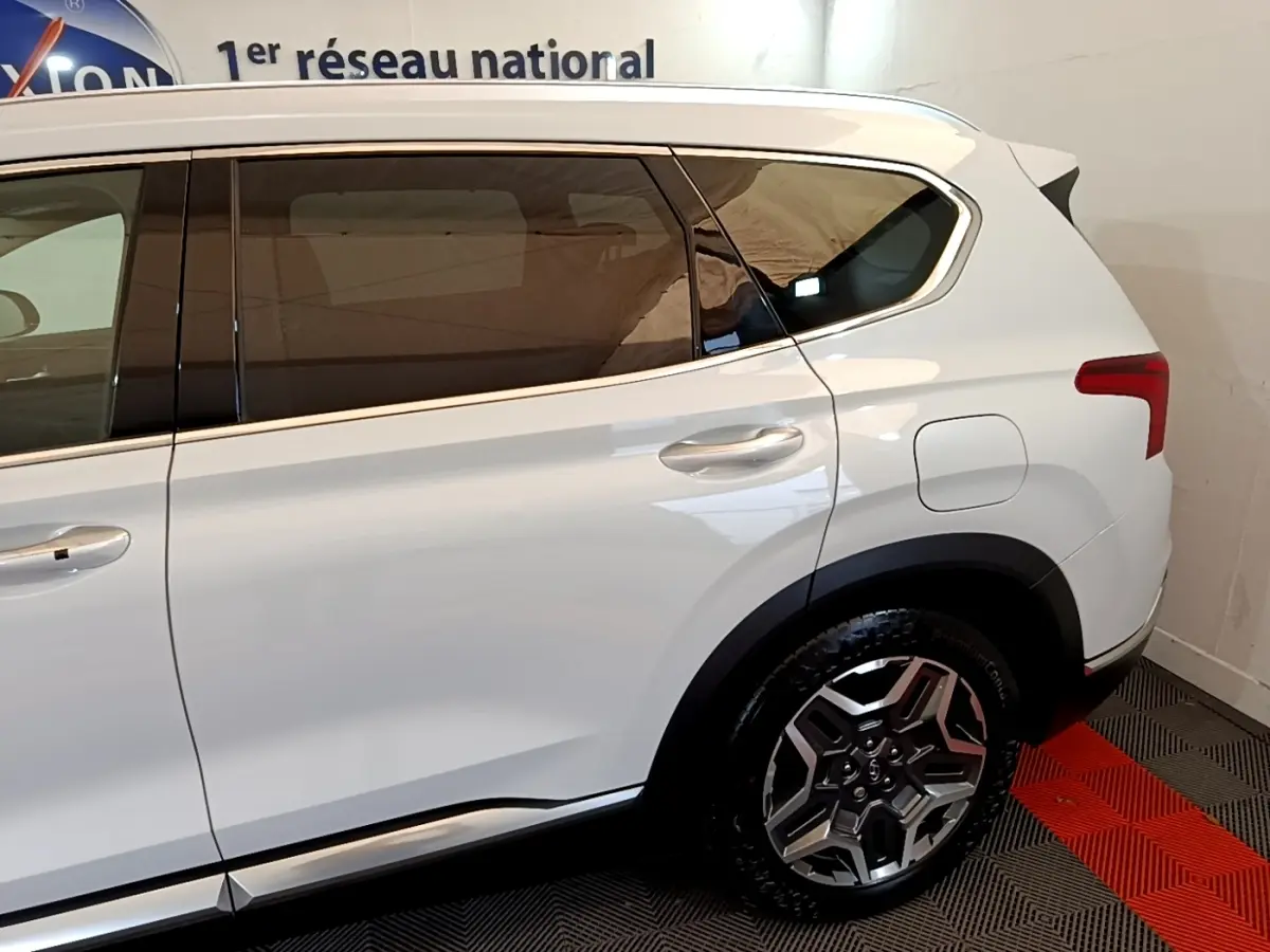 Vue latérale côté droit du Hyundai Santa Fe blanc 2022, mettant en valeur les jantes alliage et les vitres teintées.