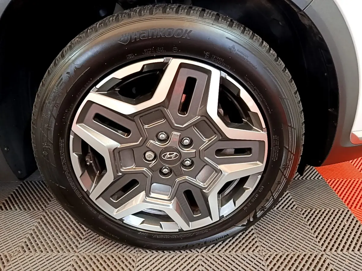 Gros plan sur la roue avant droite du Hyundai Santa Fe blanc 2022 avec jante alliage et pneu Hankook.