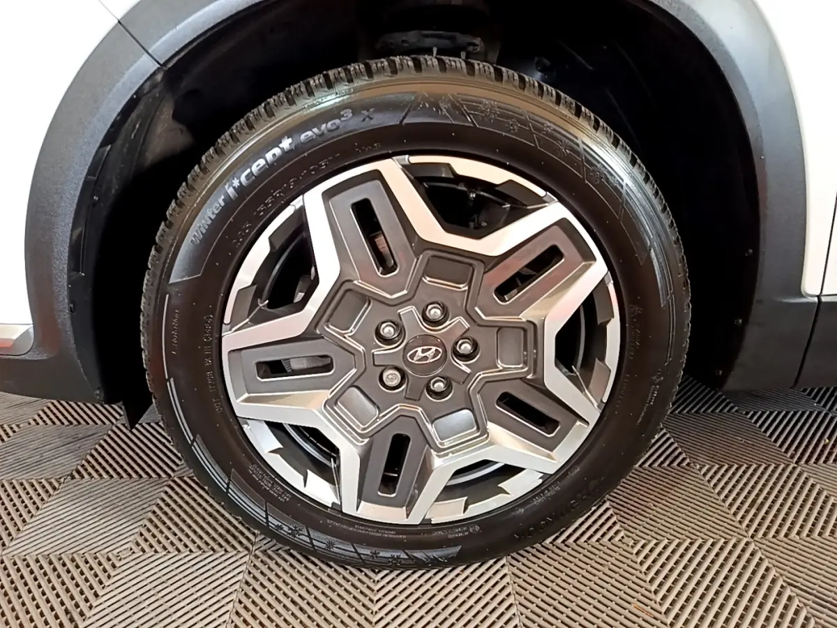 Gros plan sur la roue avant droite du Hyundai Santa Fe blanc 2022 avec jante alliage au design moderne.