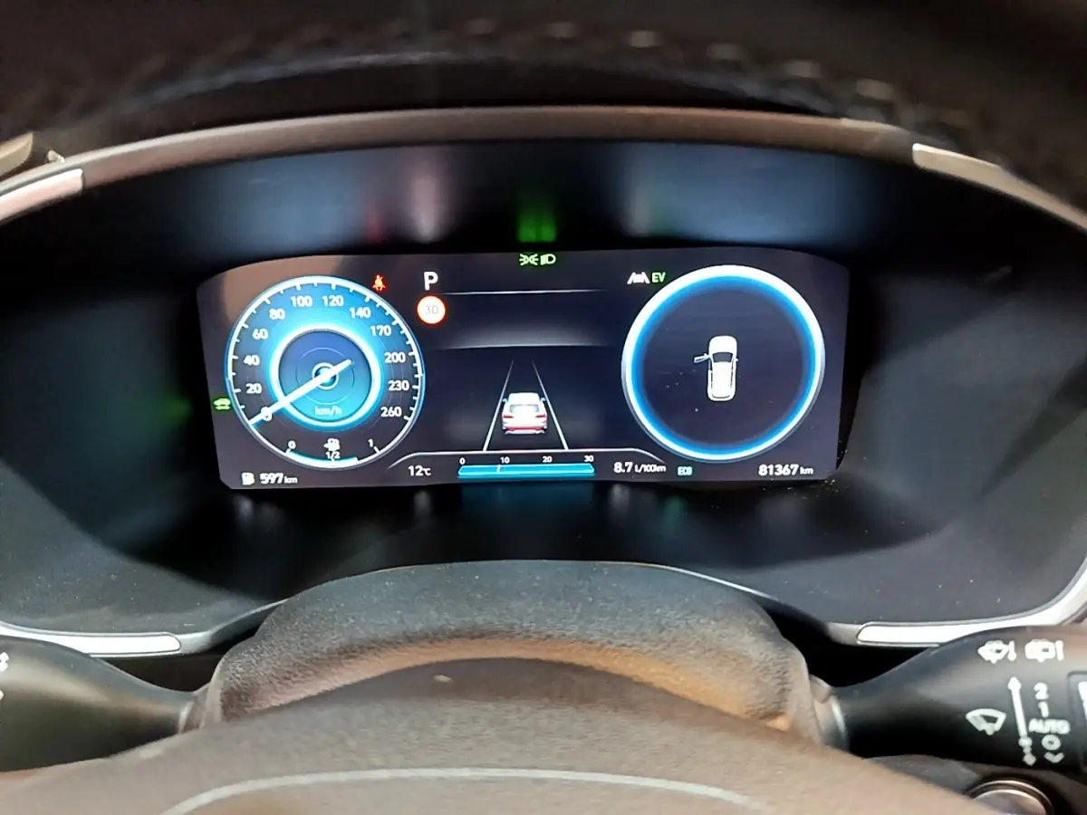 Affichage numérique du tableau de bord du Hyundai Santa Fe hybride 2022, avec vitesse, autonomie et aide au stationnement.