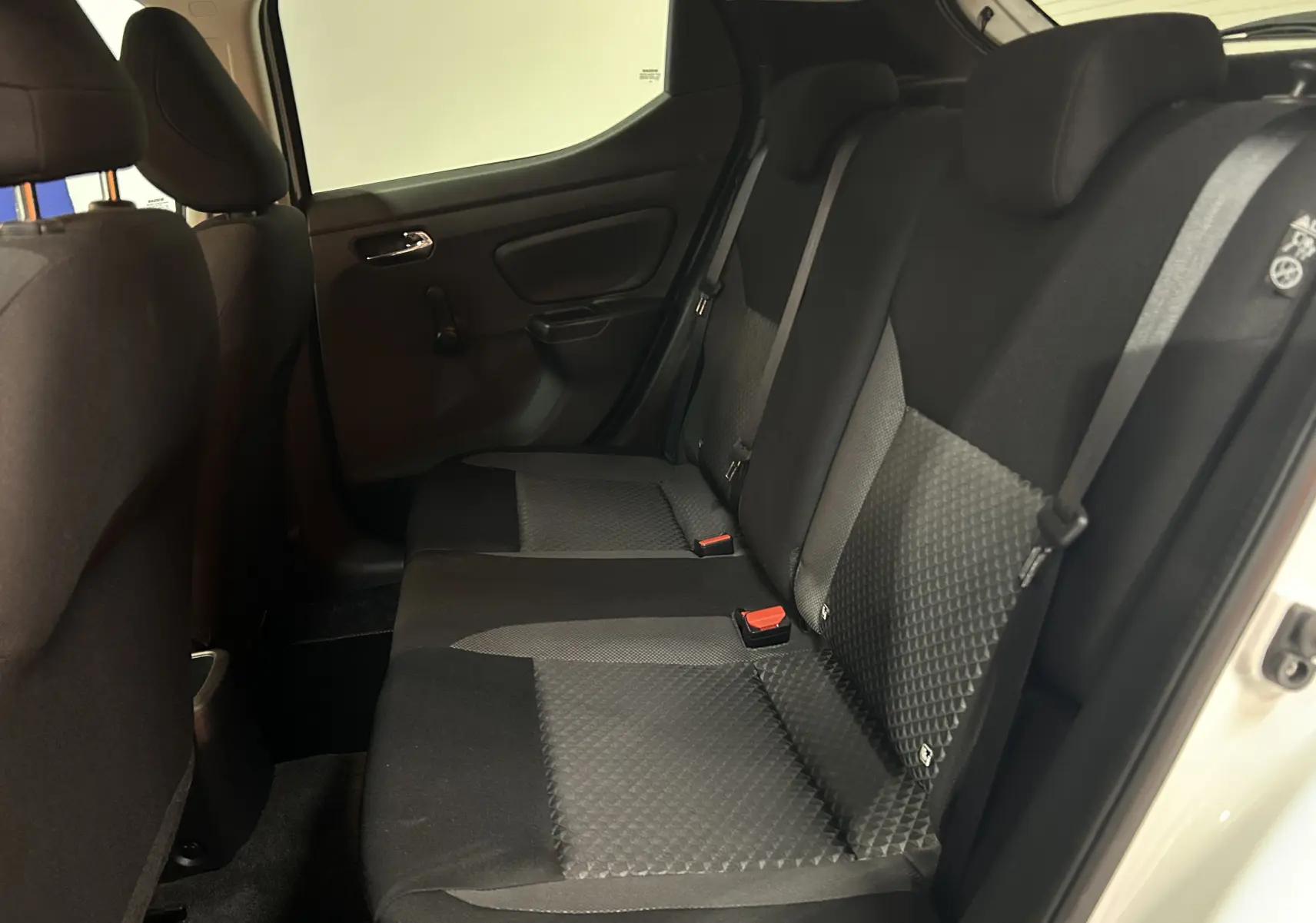 Vue intérieure côté droit des sièges arrière en tissu gris et noir d'une Nissan Micra blanche 2021 à 5 portes.