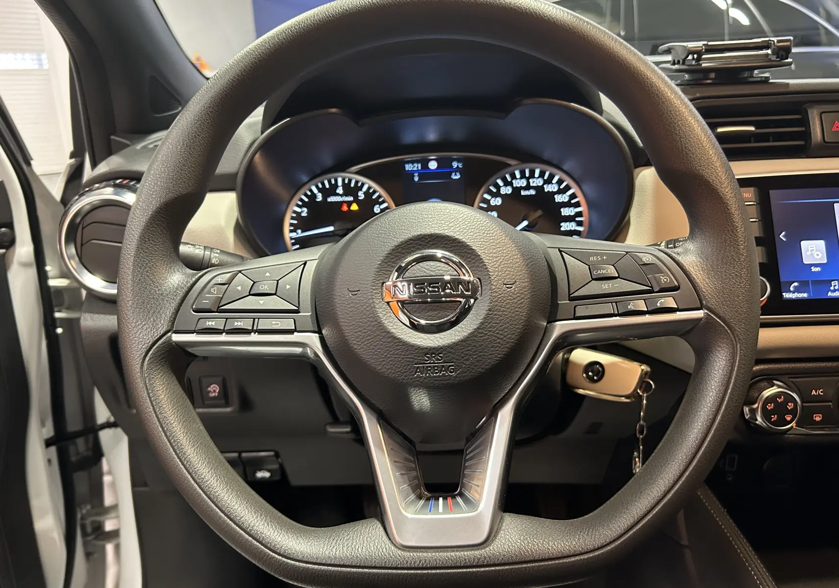 Vue rapprochée du volant noir de la Nissan Micra 2021 avec tableau de bord et clé de contact insérée.