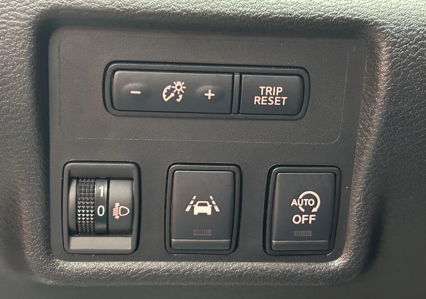 Gros plan sur les commandes de régulateur de vitesse, trip reset et aides à la conduite dans une Nissan Micra blanche 2021.