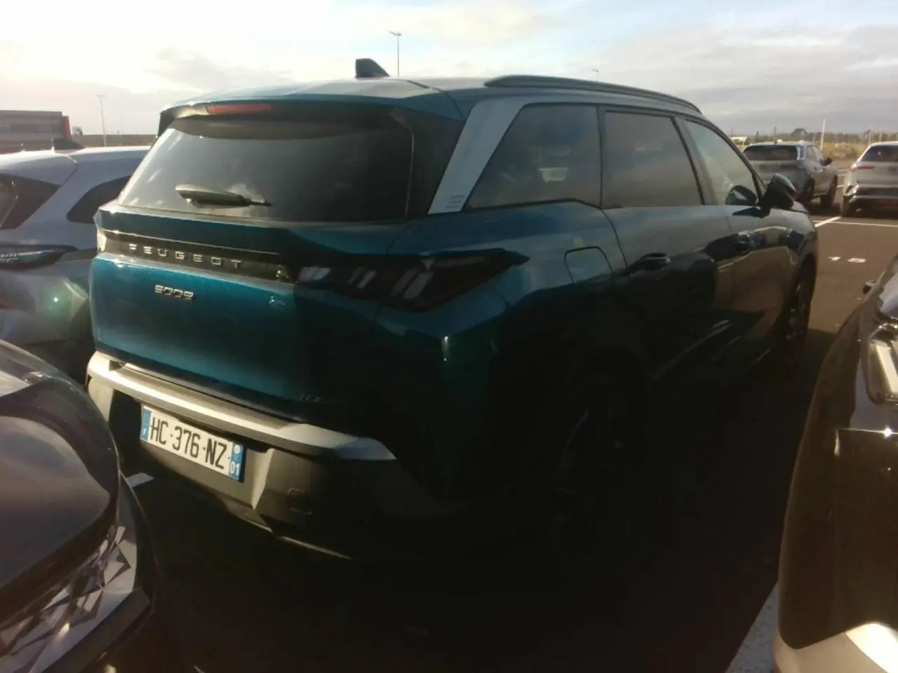 Vue 3/4 arrière droite d’un Peugeot 5008 bleu foncé avec toit clair et feux arrière à LED en forme de griffes.