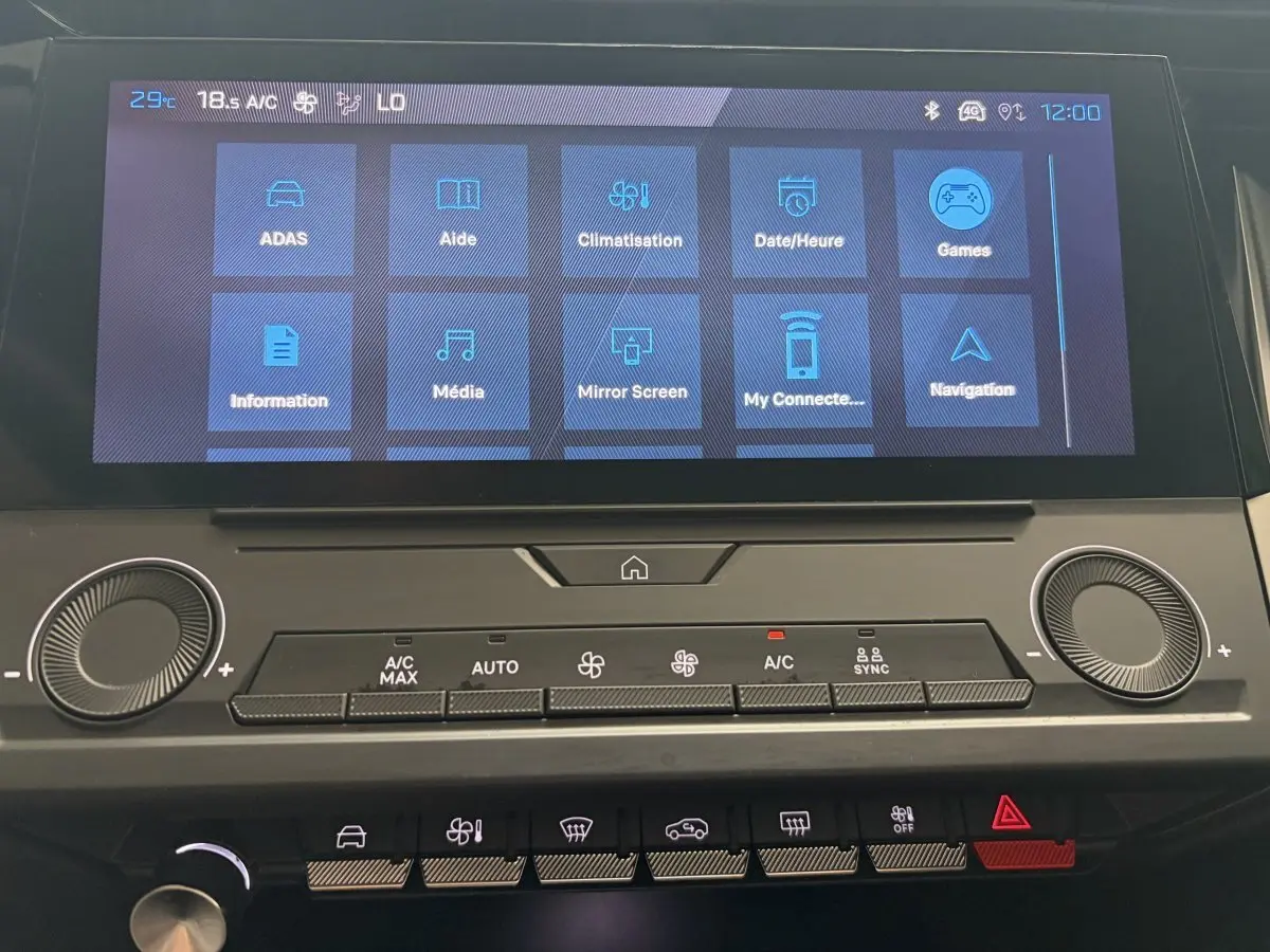 Écran tactile central affichant les menus de la climatisation et multimédia dans l’habitacle d’une Peugeot 308 blanche 2024.